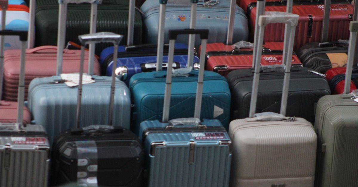 Colourful suitcases arranged with their handles extended