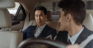 Business passenger speaking with a driver inside a car