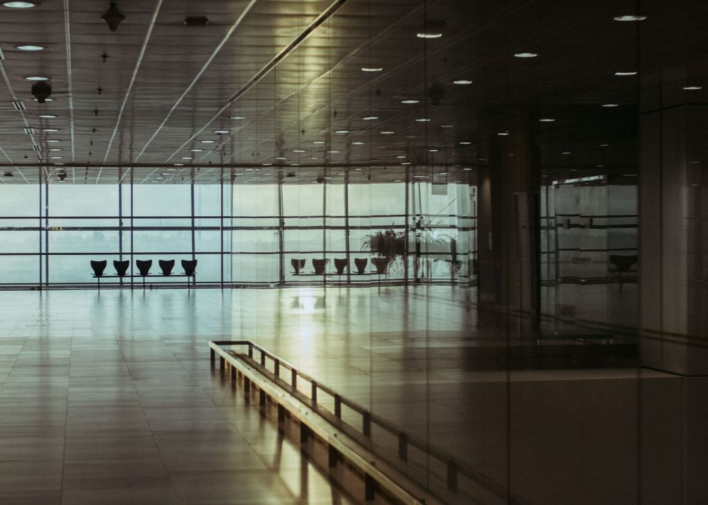 Sunlight through airport terminal windows beside rows of seats